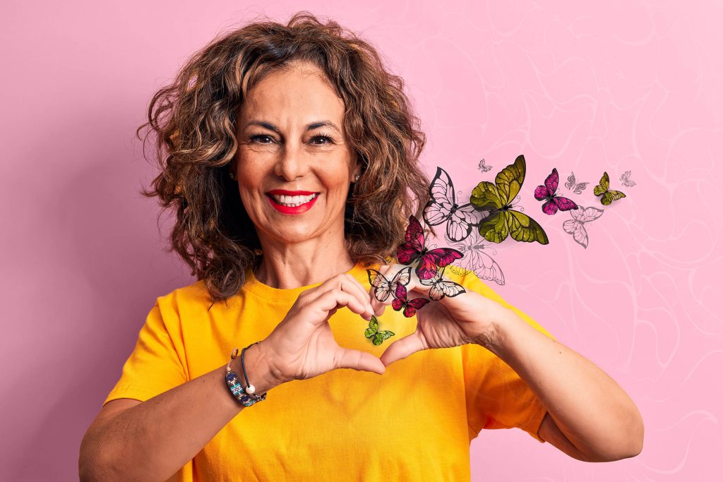 Middle age beautiful woman wearing casual turtleneck sweater over isolated white background smiling in love doing heart symbol shape with hands. Romantic concept.